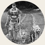 Tim walking several dogs on a trail